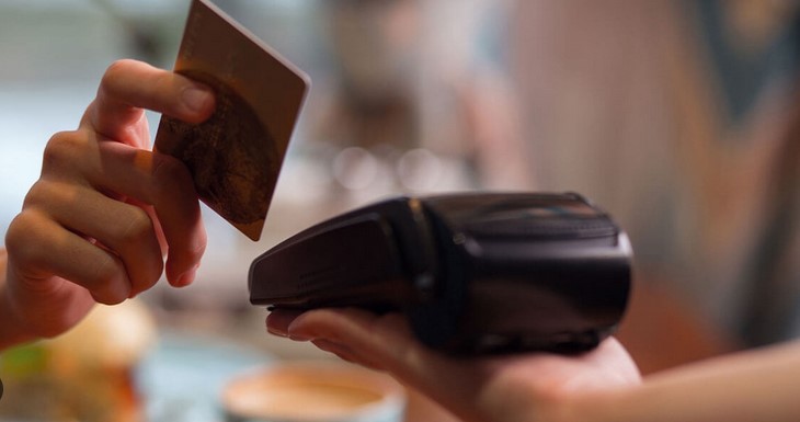 person swiping their credit card on a POS machine 